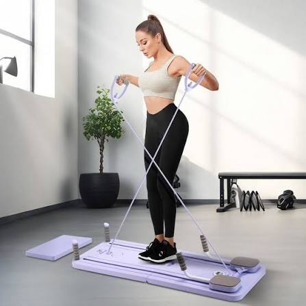 Mujer usando la banda de resistencia de la Tabla Reformer de Pilates Ardanza en color lila